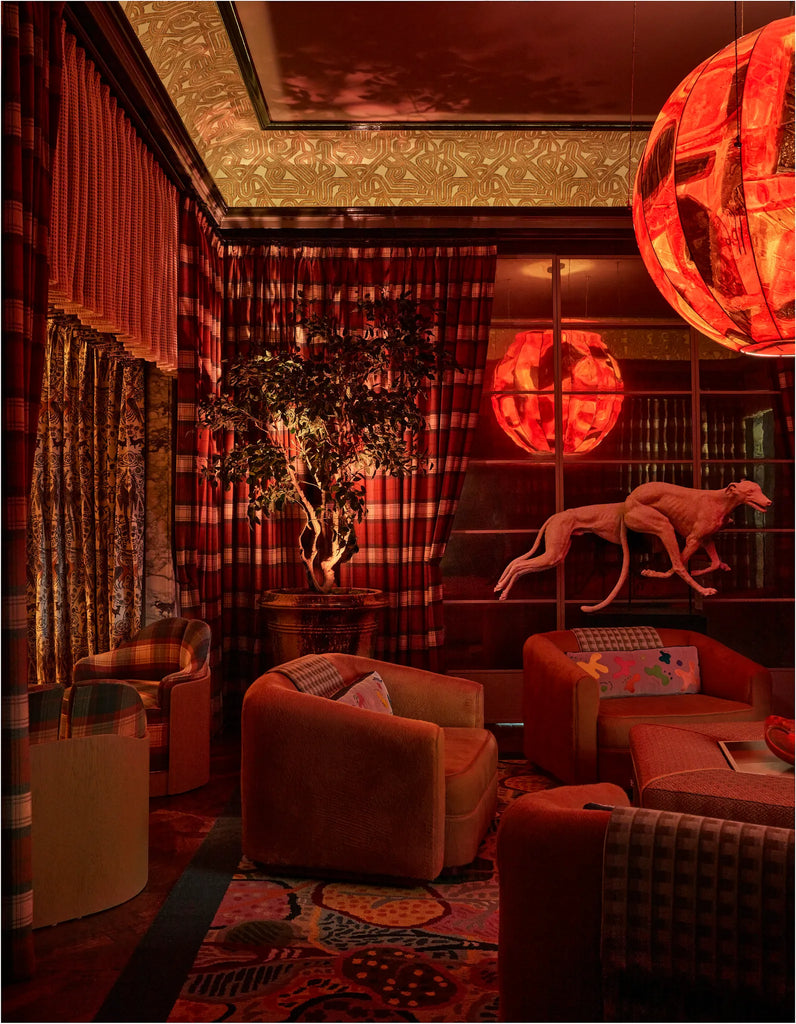Decorative interior with red and orange tones, plaid curtains, and a large round light fixture.